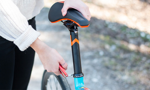 You can see a person tightening the screw on the seat post.