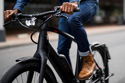 The image shows a close-up of a cyclist on a black Trek bike.