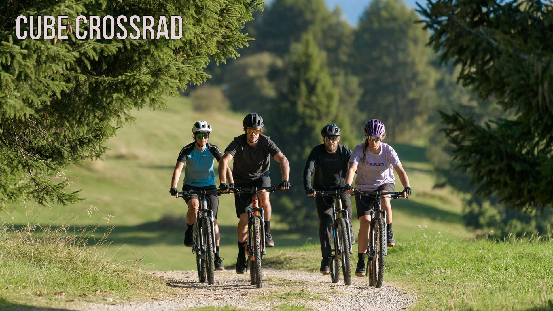 The image shows a group of cyclists riding along a forest path. The image is labeled with the title